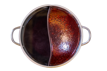 Traditional Chinese hot pot with dual flavors in yin yang pot, featuring spicy red chili broth and mild dark soup base, popular Asian cuisine for family dining and restaurant food concepts, Top view