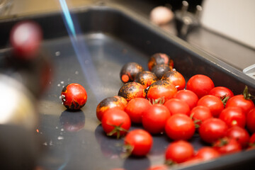 Cherry tomatoes are grilled with a gas burner