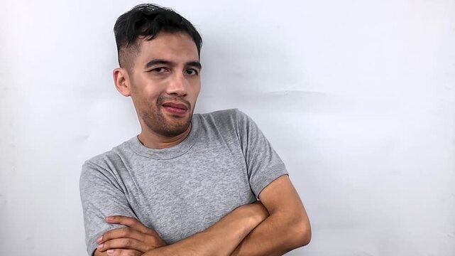 Young Man with Arms Crossed, Playful Expression.