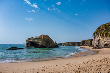 Rocky shoreline with waves at Praia da Samouqueira in Alentejo Portugal