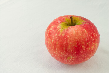 Single fresh red gala apple isolated on a minimalist bright white background. Concept of healthy eating, organic food, diet, and vitamins. Perfect image with ample copy space for text.