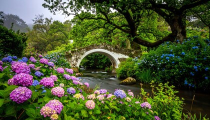 A picturesque stone arch bridge spans a babbling brook amidst vibrant blooms of hydrangeas, bathed in the soft light of a misty day.