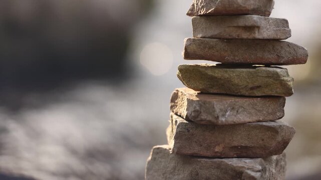 Stacked Rocks Near River Tilt Up With Background Blurred