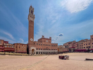 Obraz premium Siena, Tuscany, Italy: Cityscape with the Palazzo Pubblico (town hall) and the Mangia tower in Piazza del Campo prepared for the Palio dell'Assunta horse race.