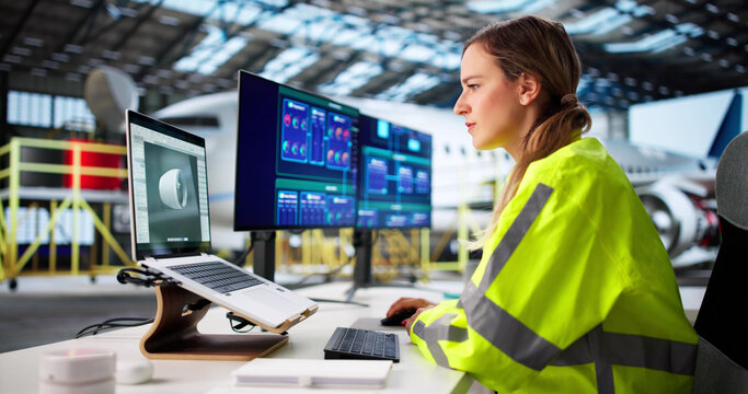 Female Engineer Analyzing Engine Blueprint On Laptop
