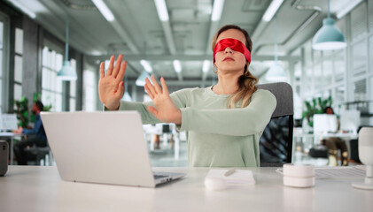 Confused Blindfolded Woman Struggling With Laptop
