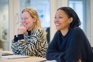 Two Businesswomen Smiling During a Meeting, Diverse Corporate Environment, Positive Interaction, Optimistic Professional Women