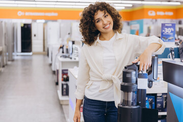 Woman Choosing Vacuum Cleaner in Electronics Store