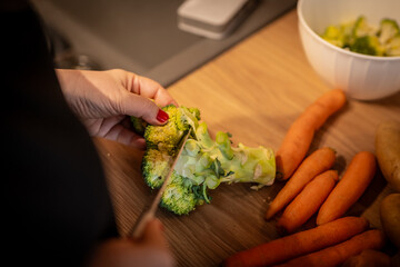 Close up photo of female hands is preparing wonderful fresh broccoli food. Chef cooking food preparing broccoli.
