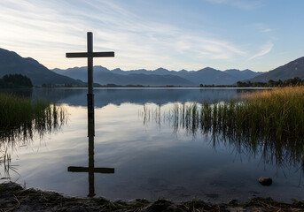 Wooden cross scenery by lakeside and meadows