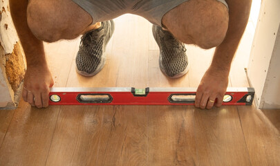  Worker using a spirit level to check laminate floor.