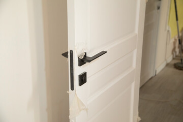 Black door handle and white door.