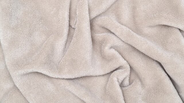 Pale brown fleece fabric texture with soft folds. Pale brown fabric background of soft and smooth textile material. Fabric texture for design and decoration. Top view.
