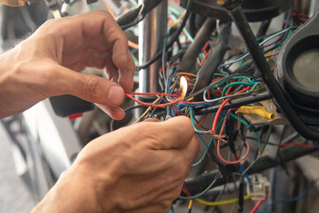 Caucasian electric repairing motorcycle electrical system.
