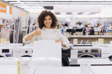 Woman Showing Thumb Up While Holding White Board in Appliance Store