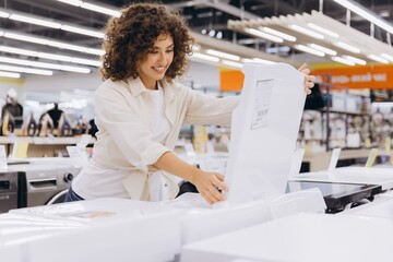 Woman choosing washing machine in appliances store