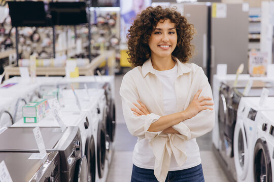 Saleswoman smiling with crossed arms in a home appliance store