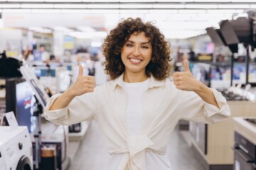 Happy customer showing thumbs up in electronics store