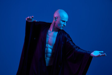 Dynamic man striking a pose in a dramatic blue light setting, showcasing strength and artistry....