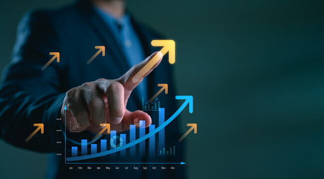 Businessman touching growth arrow and bar chart on virtual screen. Concept of business success, data-driven performance, sales increase, digital transformation and financial progress.