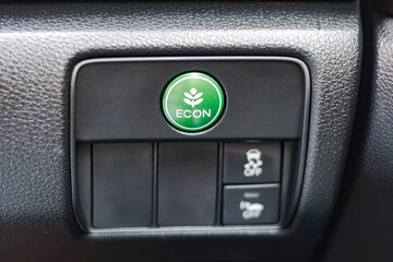 Green ECON button in car dashboard, economy switch for power saving, economical energy driving technology in EV electric vehicle and hybrid engine automobile system