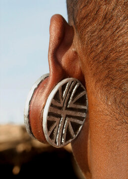 Female member of the Datoga tribe with shaven head in traditional dress, beads and earrings, Tanzania 