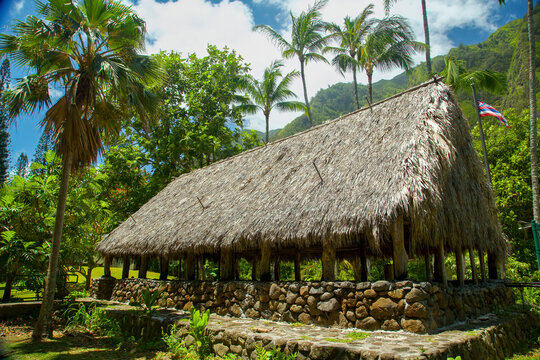 Rustic thatched-roof hut surrounded by lush palm trees and vibrant greenery. Kepaniwai park, Wailuku, Iao valley, Maui, Hawaii 