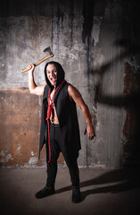 Sinister screaming man pulls a axe in a grunge abandoned room