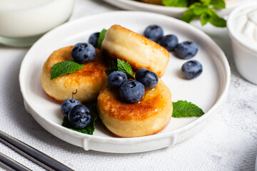 syrniki . Appetizing cheesecakes with sauce and blueberries