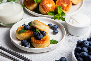syrniki . Appetizing cheesecakes with sauce and blueberries
