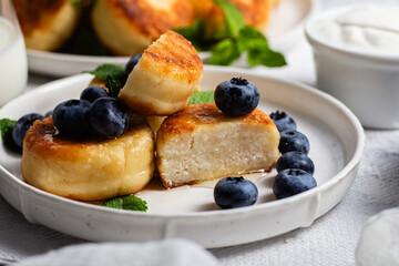 syrniki . Appetizing cheesecakes with sauce and blueberries
