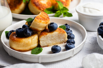 syrniki . Appetizing cheesecakes with sauce and blueberries