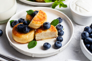 syrniki . Appetizing cheesecakes with sauce and blueberries