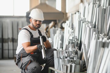 Smiling and happy indian employee. Industrial worker indoors in factory. Young technician with...
