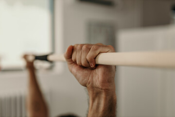 Patient performing rehabilitation exercises by holding a bar
