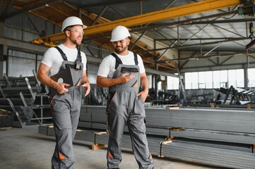 Two workers at the metalworking plant. Production of metal profiles and pipes