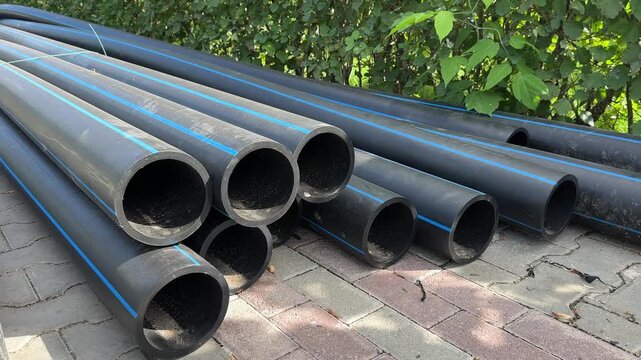 High-density polyethylene pipes. Wide black plastic pipes at a construction site in the city