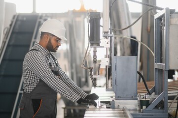 Portrait of cheerful young worker wearing hardhat at modern factory