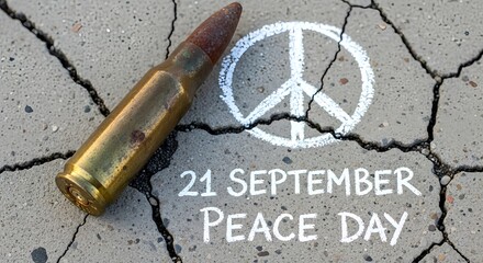 Faded bullet and peace symbol on cracked concrete, marking Peace Day