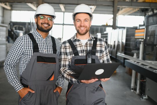 Two engineer worker working together with safety uniform and white helmet to work in industry factory