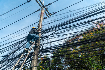 Worker Climbing Utility Pole with Cables