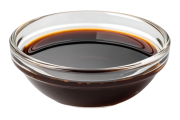 Dark brown soy sauce with liquid consistency in clear glass bowl, isolated on a transparent background
