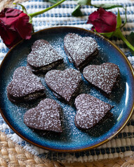 Heart-shaped dark chocolate cookies filled with chocolate and coffee cream. A recipe for lovers on Valentine's Day.