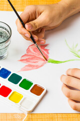 The artist paints a flower of watercolor