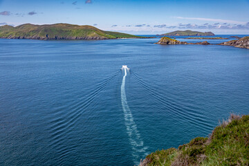 Wild atlantic way, Dingle peninsula ocean view - motor boat in the blue calm sea
