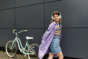 Young woman enjoying a summer day with her bicycle while listening to music outdoors