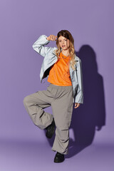 Young woman embodies summer spirit in vibrant outfit against purple backdrop