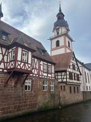 Obraz premium Traditional Half-Timbered Houses along a Canal with Church Tower in Germany