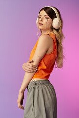 Young beautiful woman enjoying summer vibes with headphones in a vibrant studio setting © LIGHTFIELD STUDIOS