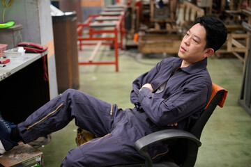 A weary worker taking a break in an industrial setting